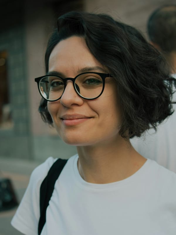Confident woman smiling with natural crow's feet, demonstrating how subtle aesthetic treatments can soften stress lines while preserving genuine expression.