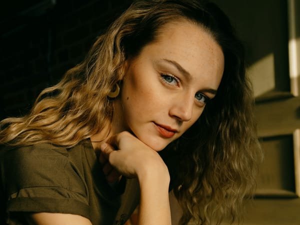 Woman resting her chin on her hand, illustrating well lifted facial contours and jawline